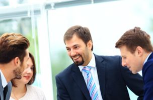 Group of male and female Executives smiling and chatting in a business meeting 