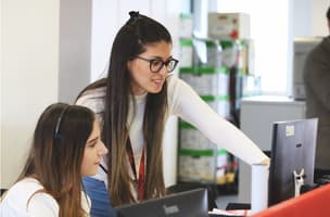 This is an image of two women helping each other out for the customer service week blog. 