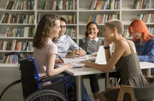 A group of diverse women meet around a table, discussing topics