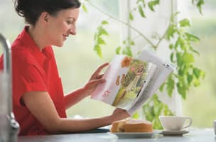 This is an image of a woman reading the Direct Mail Magazine. 