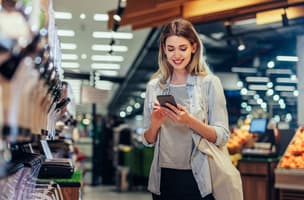 A young female using a mobile phone whilst shopping 