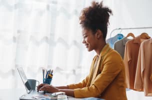 smiling female eCommerce owner looking at laptop