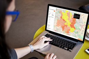 A female marketer stares at a laptop screen showing the Leafletdrop mapping tool