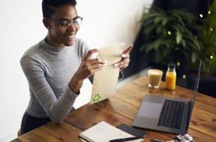 This is an image of a woman opening environmentally friendly mail.