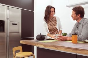  couple drinking coffee in a kitchen 