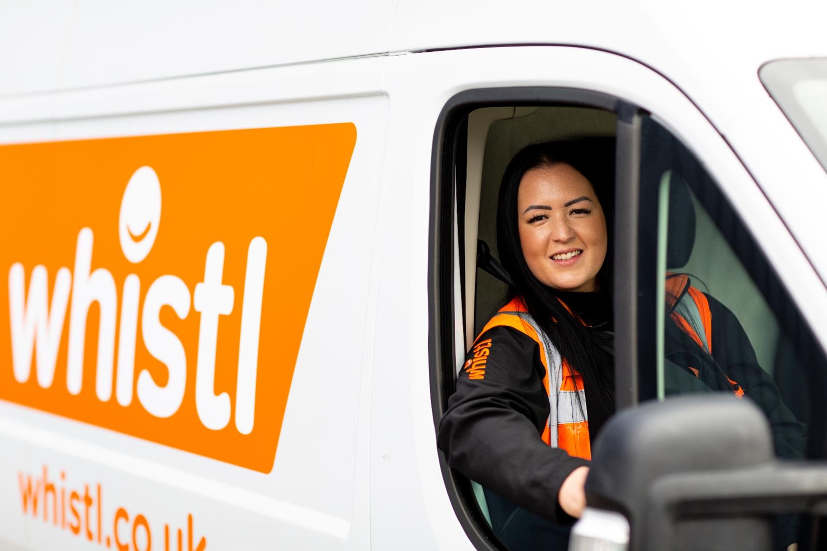 lady in whistl parcel delivery van smiling 