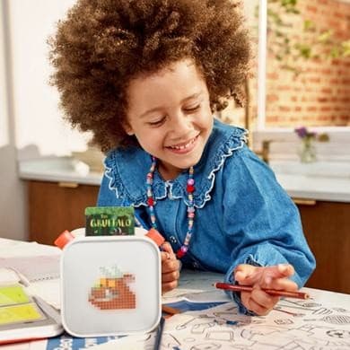 A young child listening to the Gruffalo story through a Yoto player. 